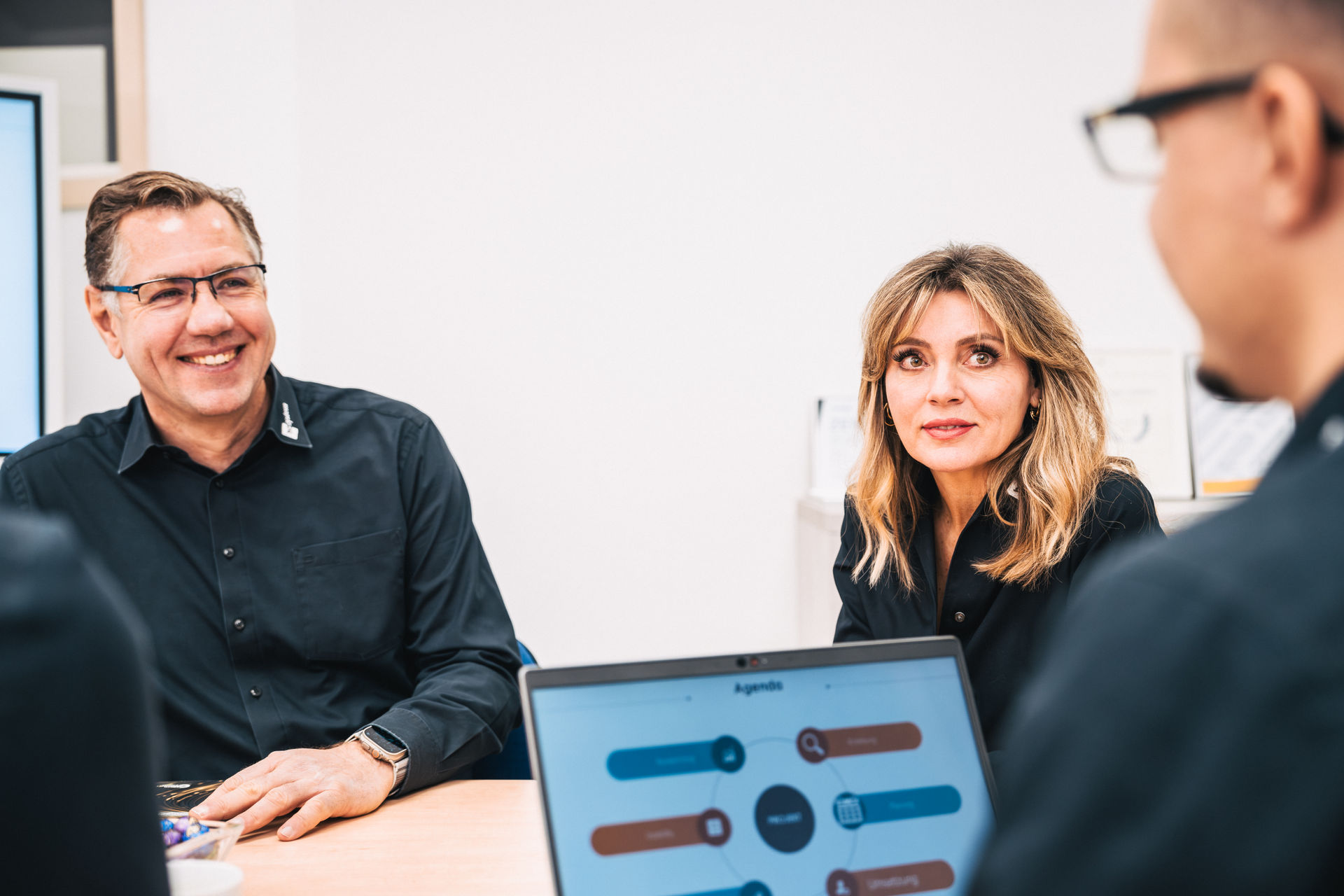 Viktor Leicht und Elina Leicht von hcsystem im Beratungsgespräch am Besprechungstisch, im Vordergrund ein Notebook.