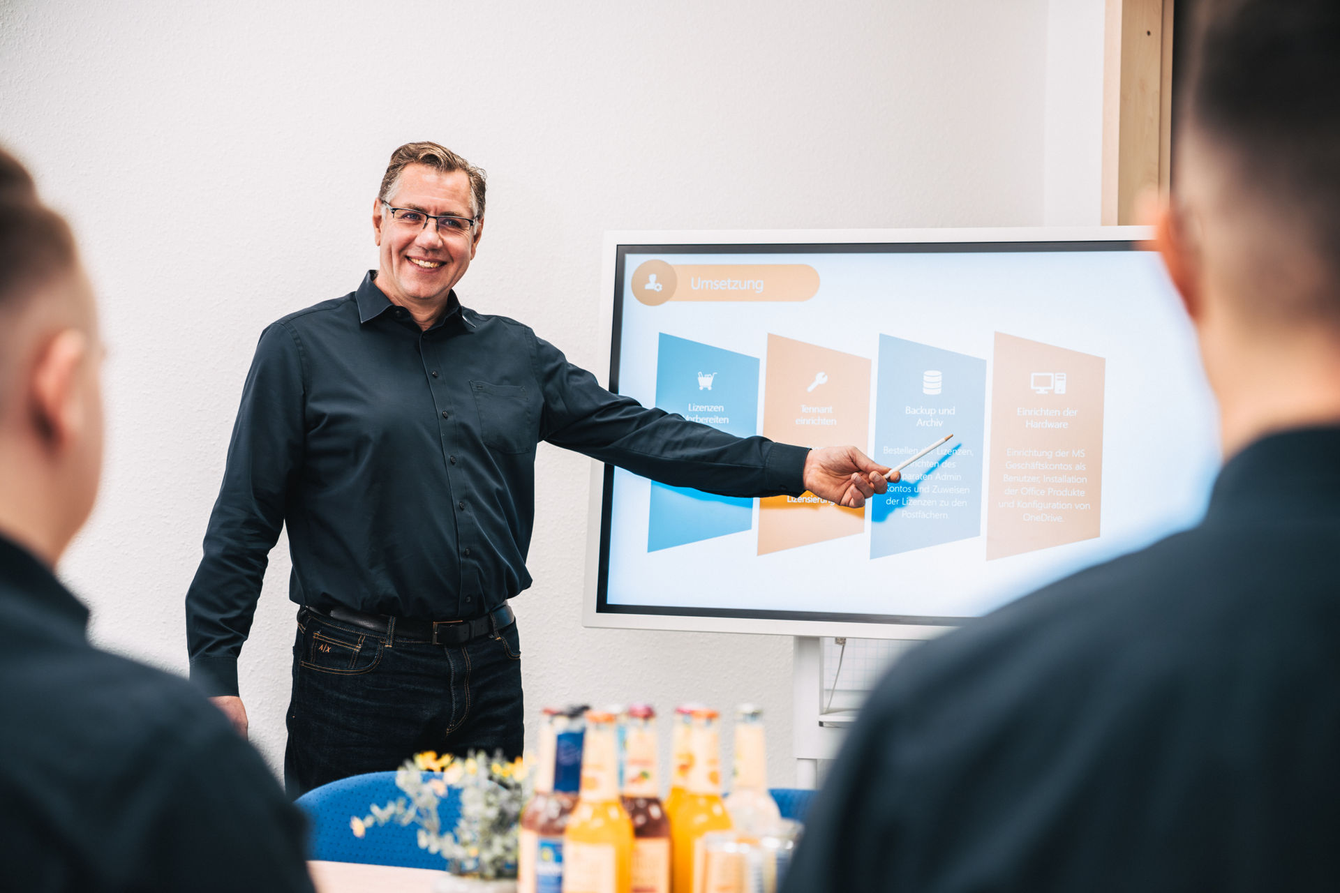 Viktor Leicht von hcsystem erklärt an einem Bildschirm die Schritte einer Microsoft-365-Einführung.