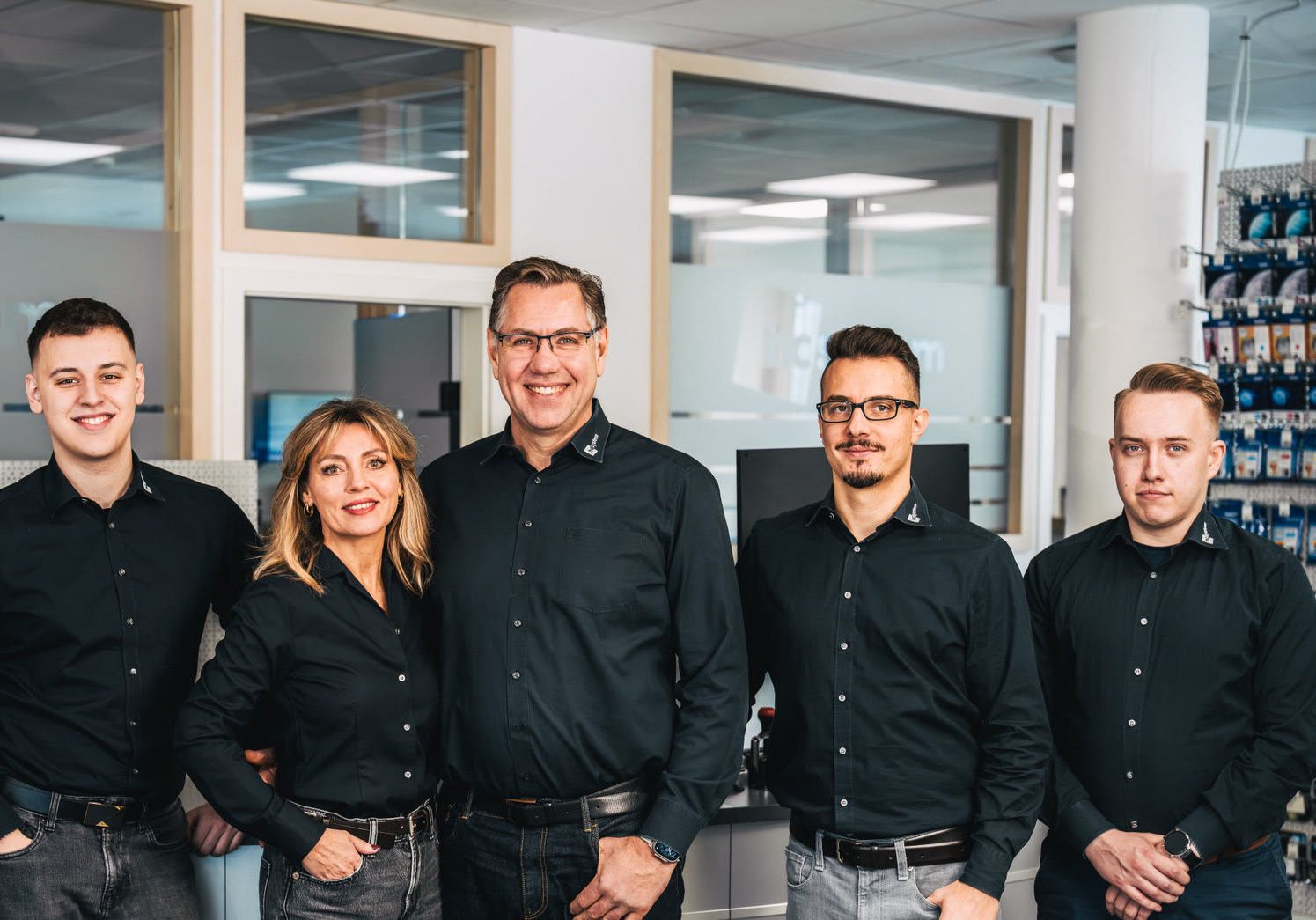 Fünf Mitarbeitende von hcsystem in Firmenhemden im Büro in Calw.